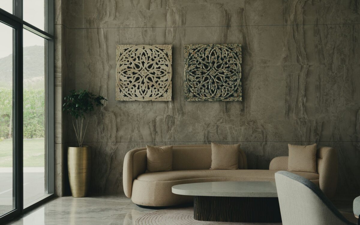 Elegant living room featuring a curved sofa, textured walls, and natural light streaming through large windows.